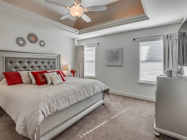 bedroom featuring carpet flooring, ceiling fan, crown molding, and a tray ceiling