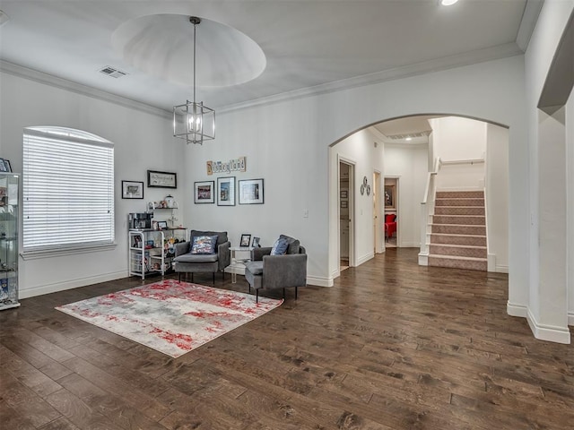 living room featuring crown molding, dark wood-type flooring, and a chandelier