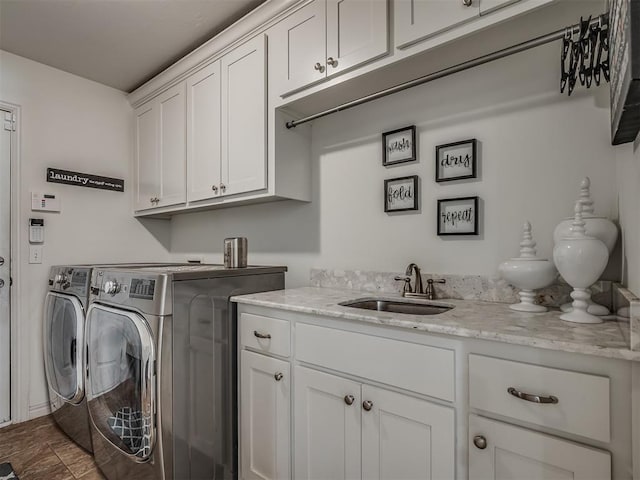 laundry room with cabinets, separate washer and dryer, and sink