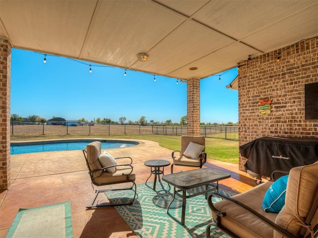 view of patio / terrace with a fenced in pool and a grill