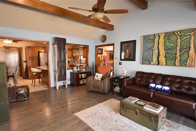 living room featuring hardwood / wood-style floors, vaulted ceiling with beams, and ceiling fan