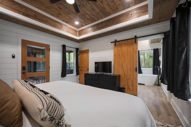 bedroom featuring ceiling fan, light wood-type flooring, wood ceiling, and wooden walls