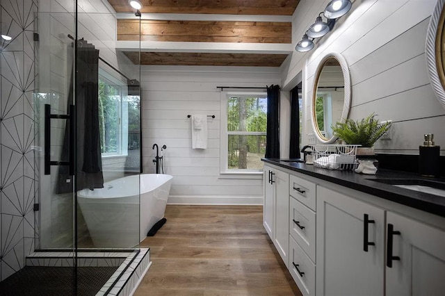 bathroom with vanity, wooden walls, shower with separate bathtub, beam ceiling, and wood-type flooring