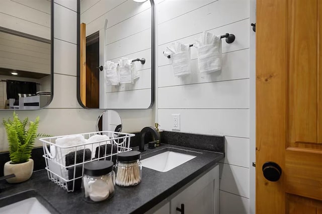 bathroom with vanity and wood walls