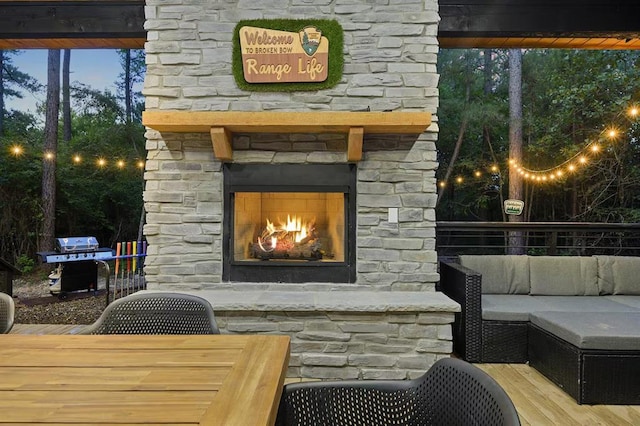 patio terrace at dusk with area for grilling and an outdoor stone fireplace