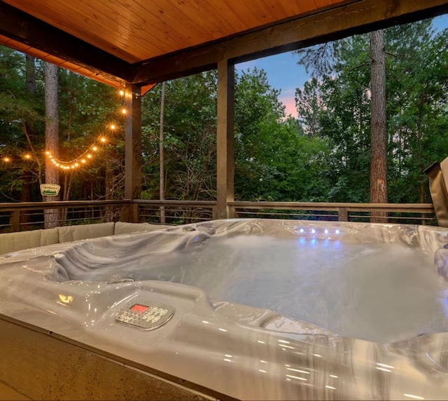 unfurnished sunroom with a hot tub and wood ceiling