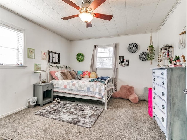 bedroom with ceiling fan, ornamental molding, and carpet flooring