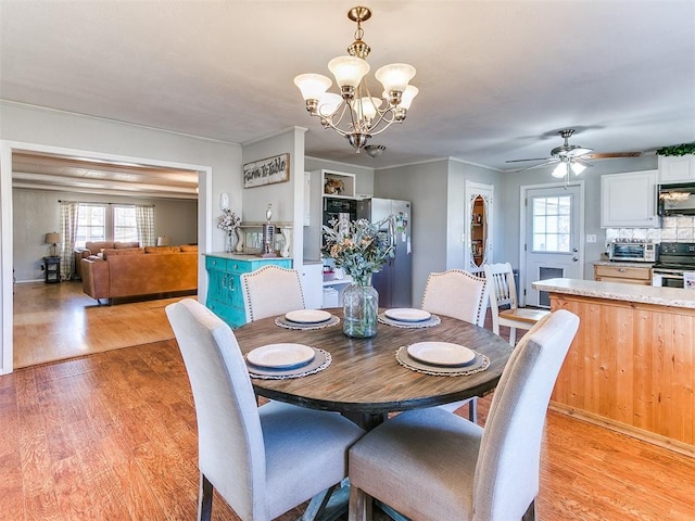 dining room with light wood-type flooring and ceiling fan with notable chandelier