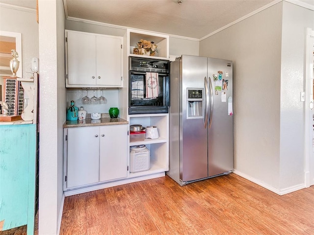 kitchen with oven, light hardwood / wood-style flooring, ornamental molding, white cabinets, and stainless steel fridge