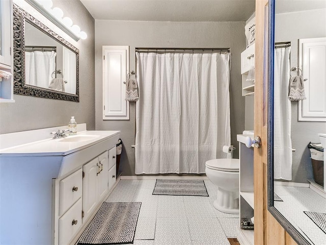 bathroom with toilet, a shower with shower curtain, and vanity