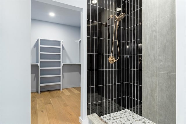 bathroom featuring hardwood / wood-style floors and a tile shower