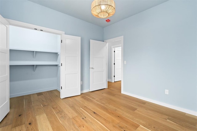 unfurnished bedroom with light hardwood / wood-style flooring and a closet