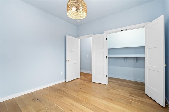 unfurnished bedroom with light hardwood / wood-style flooring and a closet