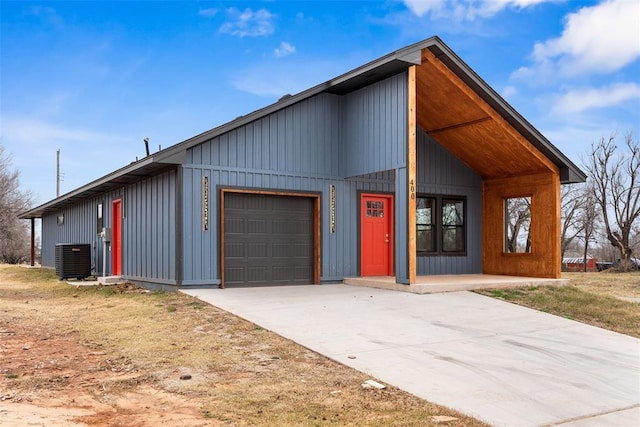 view of front of house with central air condition unit and a garage