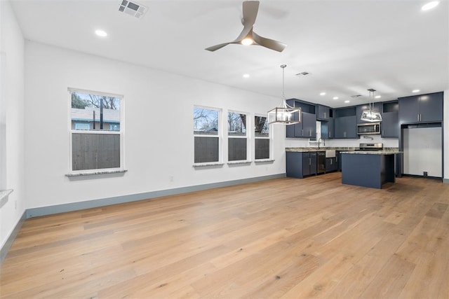 kitchen featuring stainless steel appliances, ceiling fan, pendant lighting, light hardwood / wood-style flooring, and a kitchen island