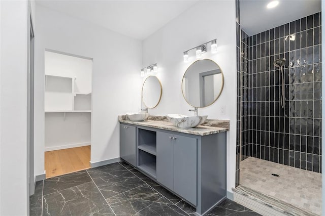 bathroom featuring tiled shower and vanity