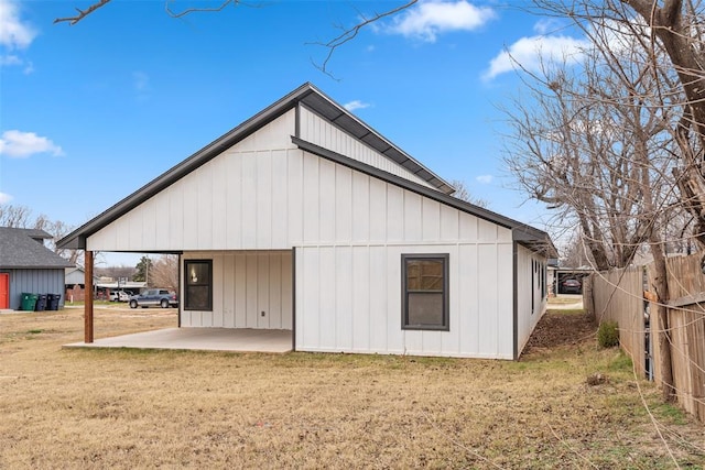 back of property with a lawn and a patio area