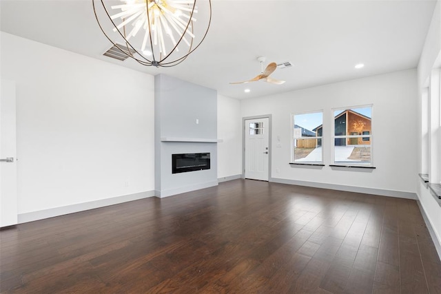 unfurnished living room featuring ceiling fan with notable chandelier and dark hardwood / wood-style flooring