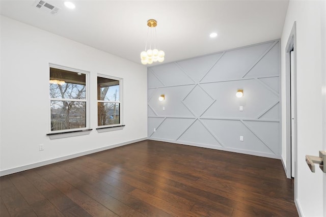 unfurnished room featuring dark hardwood / wood-style floors and an inviting chandelier