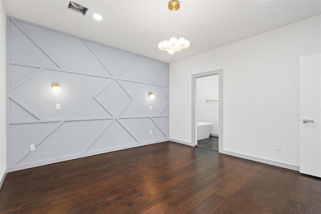 unfurnished room with dark hardwood / wood-style floors and an inviting chandelier