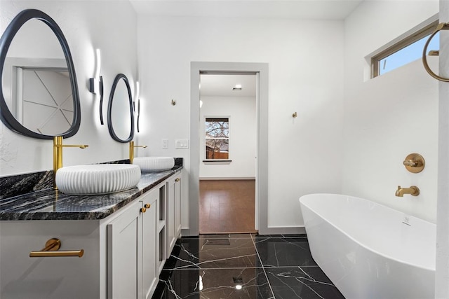 bathroom with a tub and vanity