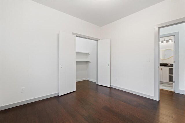 unfurnished bedroom featuring a closet and dark wood-type flooring