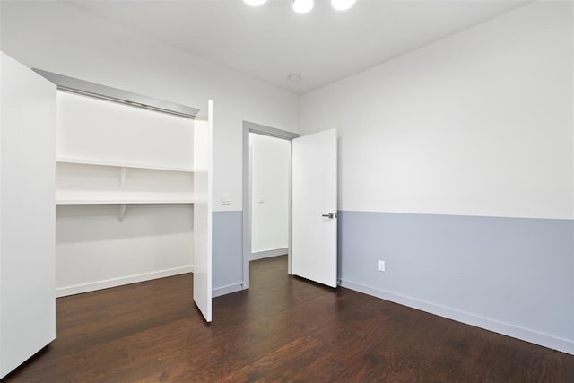 unfurnished bedroom featuring a closet and dark hardwood / wood-style floors