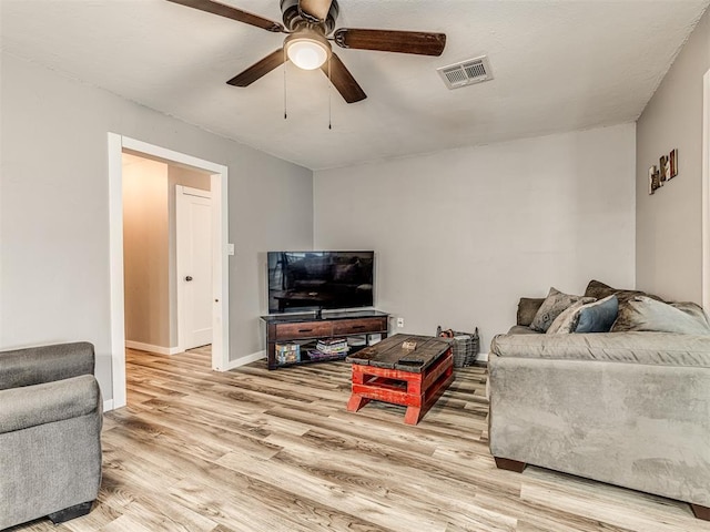 living room with light hardwood / wood-style flooring and ceiling fan