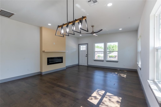 unfurnished living room featuring dark hardwood / wood-style flooring and an inviting chandelier