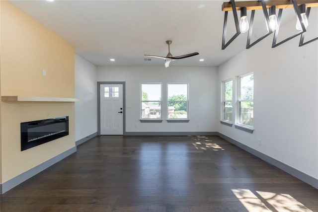 unfurnished living room with dark hardwood / wood-style floors and ceiling fan