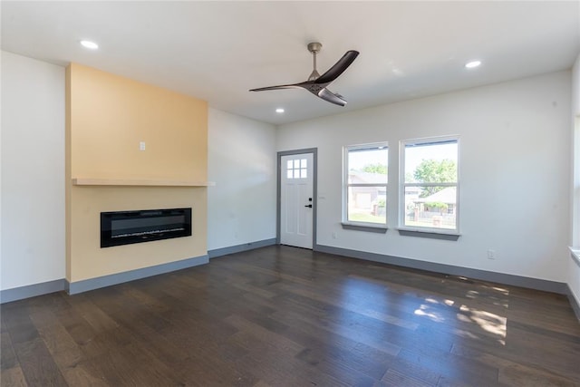 unfurnished living room with ceiling fan and dark hardwood / wood-style floors