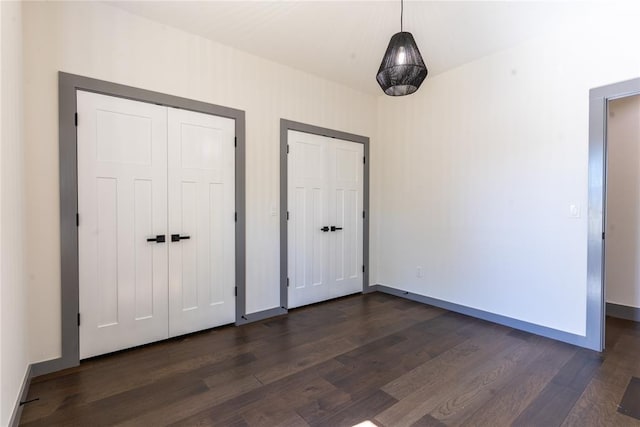 unfurnished bedroom with dark wood-type flooring