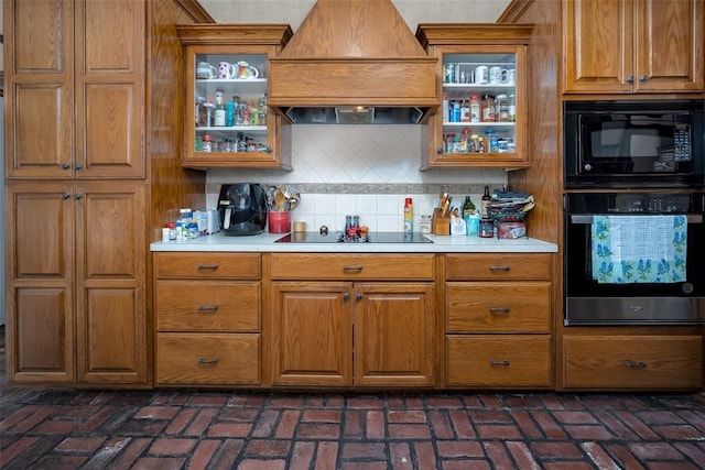 kitchen with custom range hood, backsplash, and black appliances