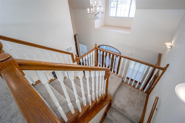 stairs featuring an inviting chandelier