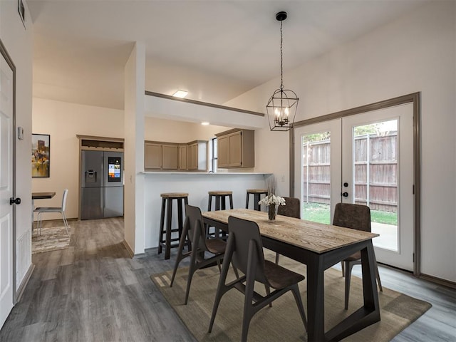 dining room featuring dark hardwood / wood-style flooring, french doors, a chandelier, and plenty of natural light