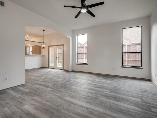 unfurnished living room with hardwood / wood-style flooring, ceiling fan, and french doors