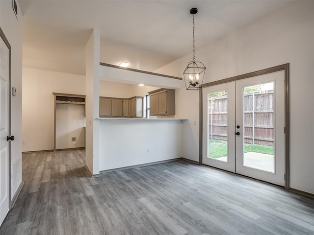 kitchen with hanging light fixtures, french doors, light hardwood / wood-style floors, and an inviting chandelier