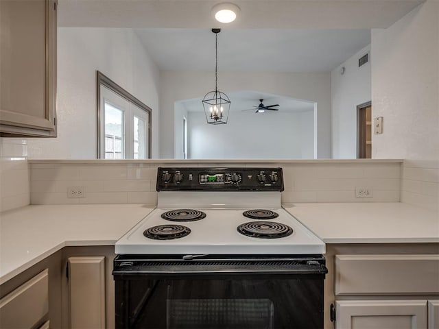 kitchen with white electric range oven, ceiling fan with notable chandelier, gray cabinets, and hanging light fixtures