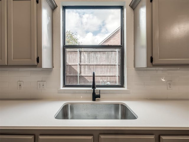 kitchen with decorative backsplash, gray cabinets, and sink