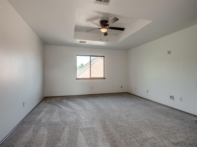 unfurnished room with carpet, ceiling fan, and a raised ceiling