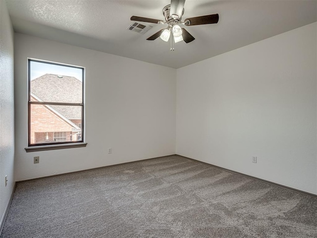 carpeted empty room featuring a textured ceiling and ceiling fan