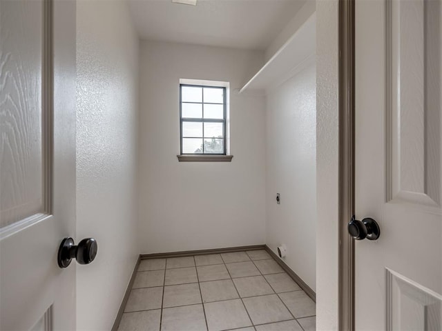 interior space with electric dryer hookup and light tile patterned flooring