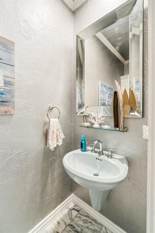 301 Club House Dr, Shawnee, OK 74801 - bathroom featuring a textured wall, baseboards, marble finish flooring, and a sink