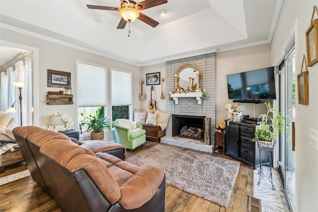 301 Club House Dr, Shawnee, OK 74801 - living room with ceiling fan, a fireplace, wood finished floors, crown molding, and a tray ceiling