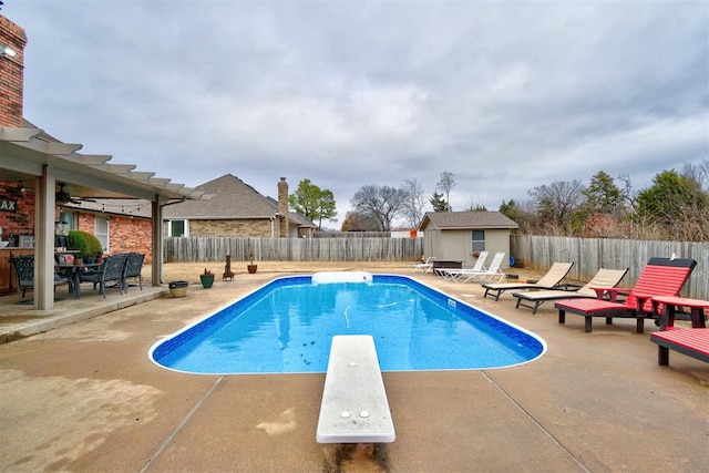 301 Club House Dr, Shawnee, OK 74801 - view of pool featuring a diving board, a patio area, a fenced backyard, and an outdoor structure