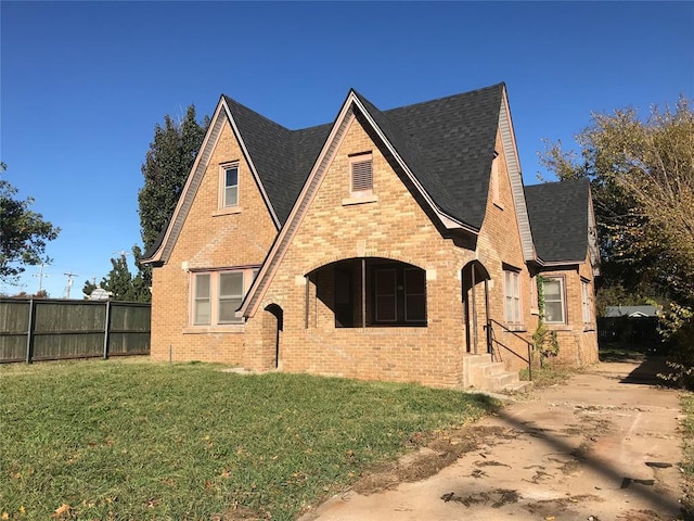 tudor house featuring a front lawn