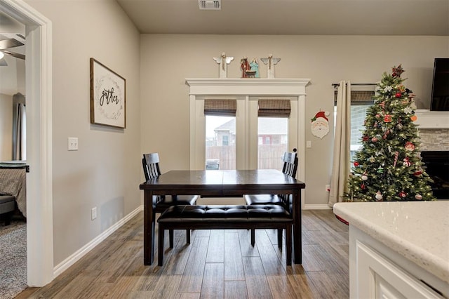 dining area with hardwood / wood-style floors and a fireplace