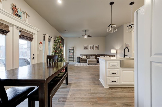 dining room featuring ceiling fan with notable chandelier and sink