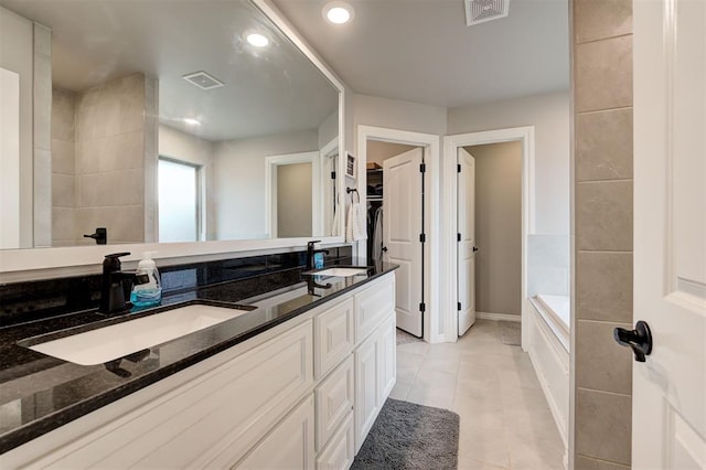 bathroom with tile patterned floors, vanity, and a bath