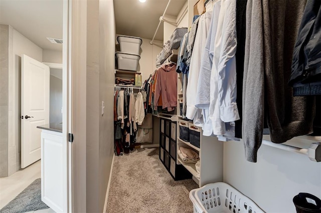 walk in closet featuring light carpet